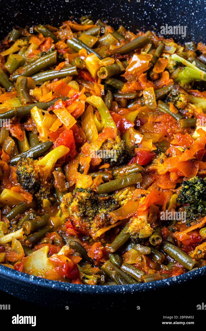 Faire cuire les légumes dans une poêle. Cuisson. Cuisine végétalienne. Brocoli, oignons