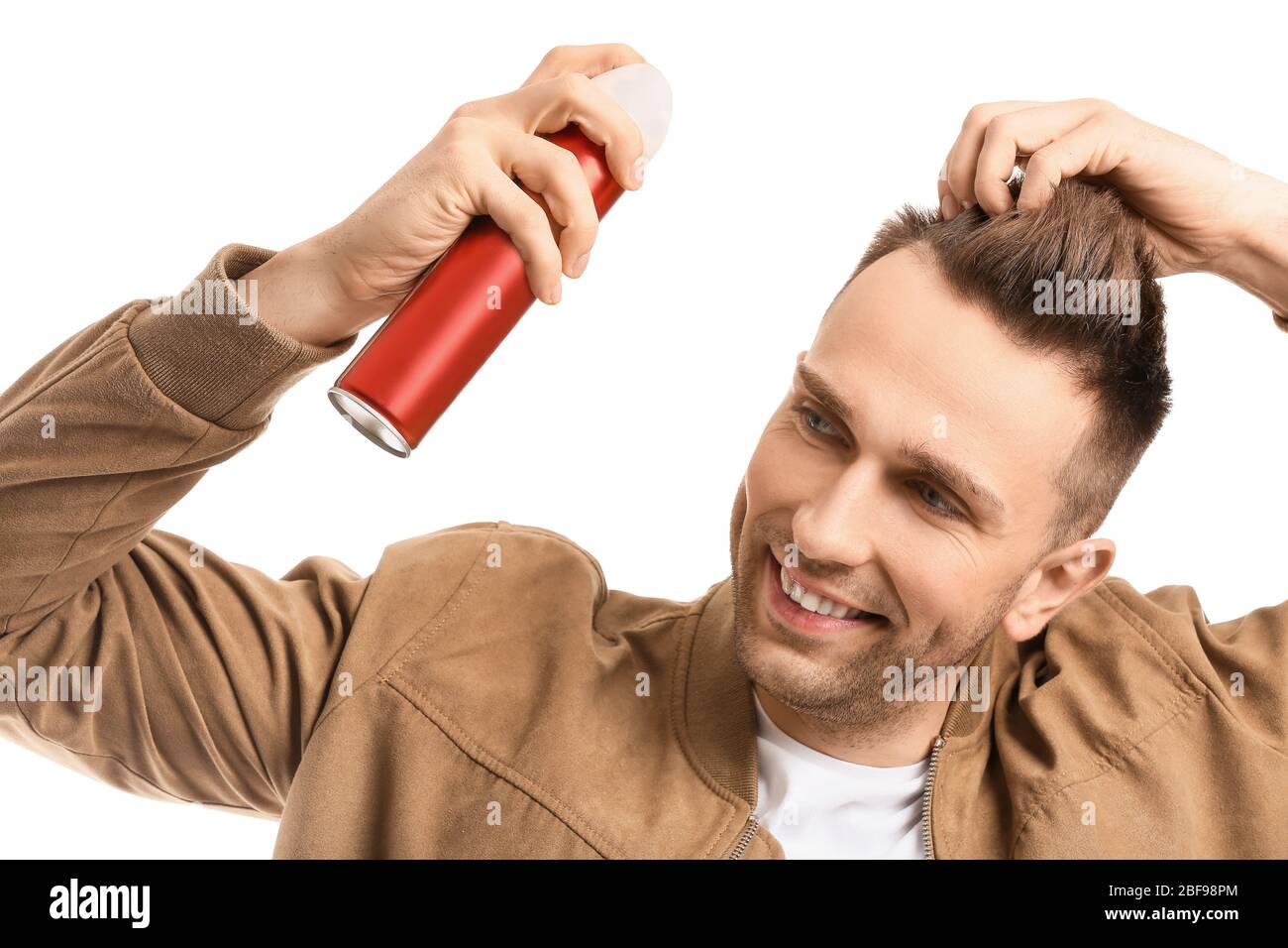 Beau jeune homme avec spray pour cheveux sur fond blanc Photo Stock - Alamy