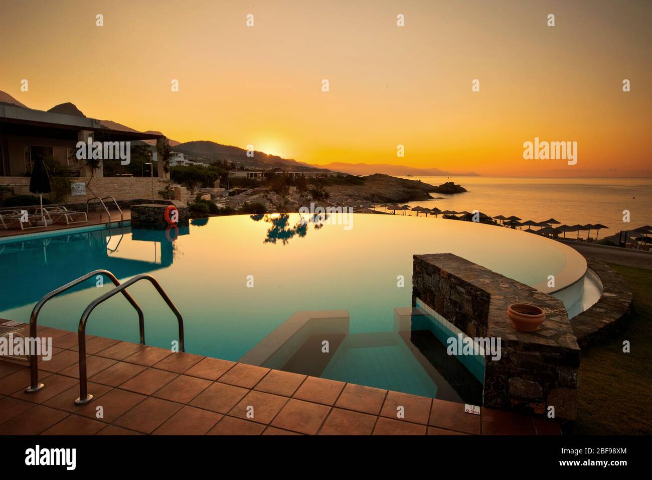 Lever du soleil au bord de la piscine de l'hôtel de plage de Kakkos (adultes uniquement), Koutsounari, municipalité d'Ierapetra, Lassithi, Crète, Grèce. Banque D'Images