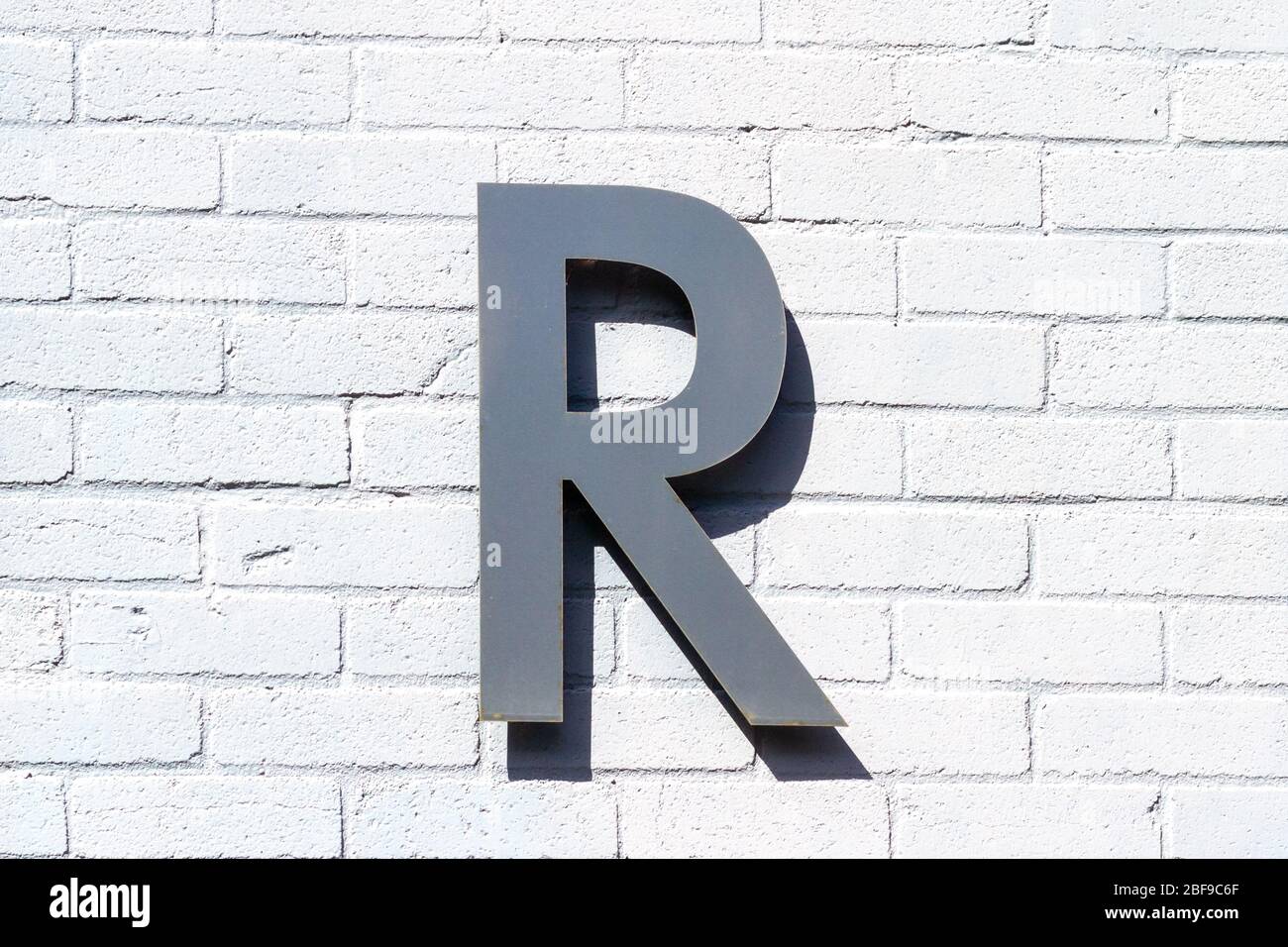 La lettre R comme lettre majuscule sur un mur de briques blanches Banque D'Images