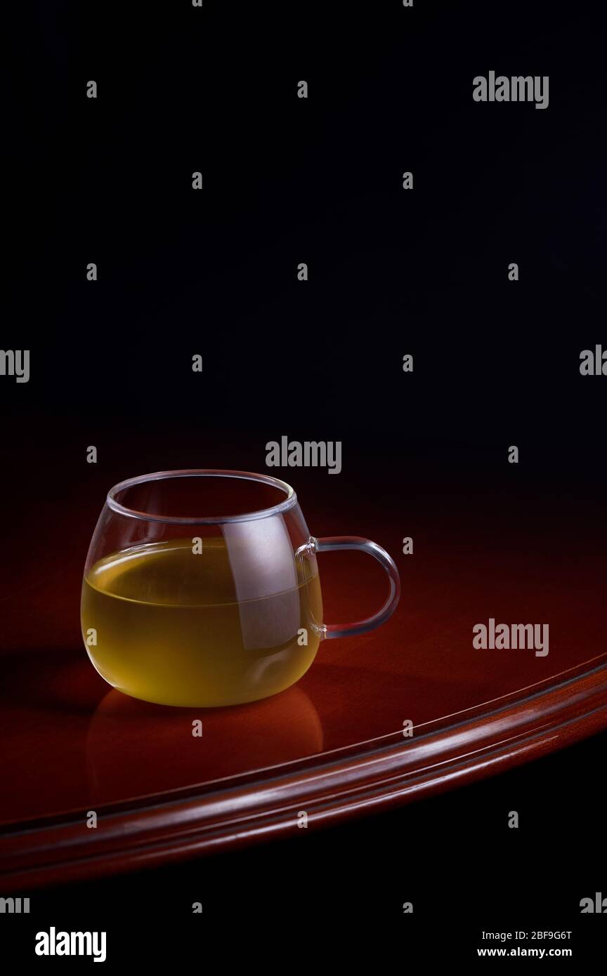 Tasse de perfusion jaune sur une table luxueuse avec un fond noir Banque D'Images