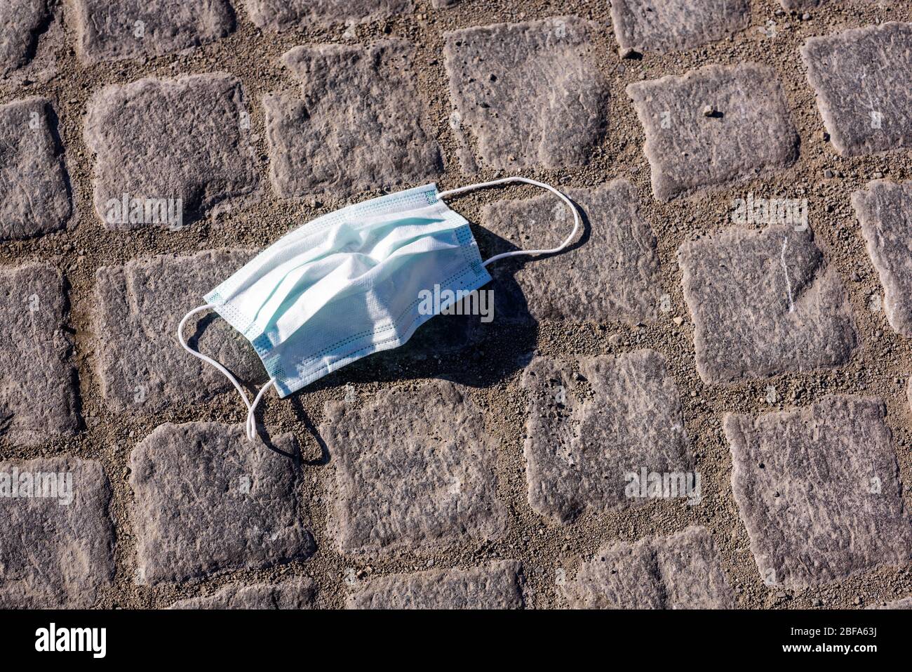 Masque médical sur le plancher de la rue. Protection contre les virus matériel de soins de santé. Utilisé et sale. Épidémie de Covid-19 ou de coronavirus. Banque D'Images