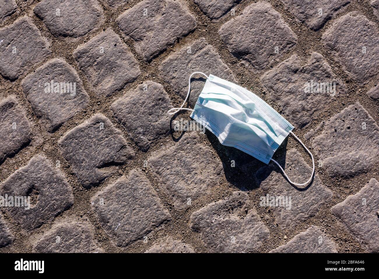 Masque médical sur le plancher de la rue. Protection contre les virus matériel de soins de santé. Utilisé et sale. Épidémie de Covid-19 ou de coronavirus. Banque D'Images