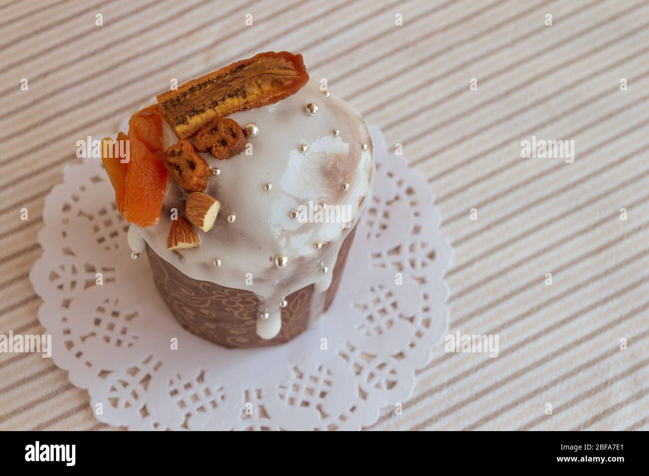 Vue sur le kulich traditionnel orthodoxe de Pâques. Délicieux gâteau élégant sur la serviette blanche avec des détails de coupe décorés de bananes séchées, abricots, Banque D'Images