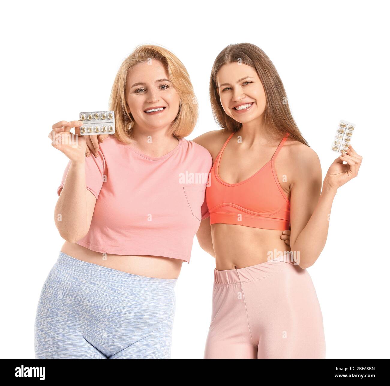 Femmes avec des pilules de perte de poids sur fond blanc Banque D'Images