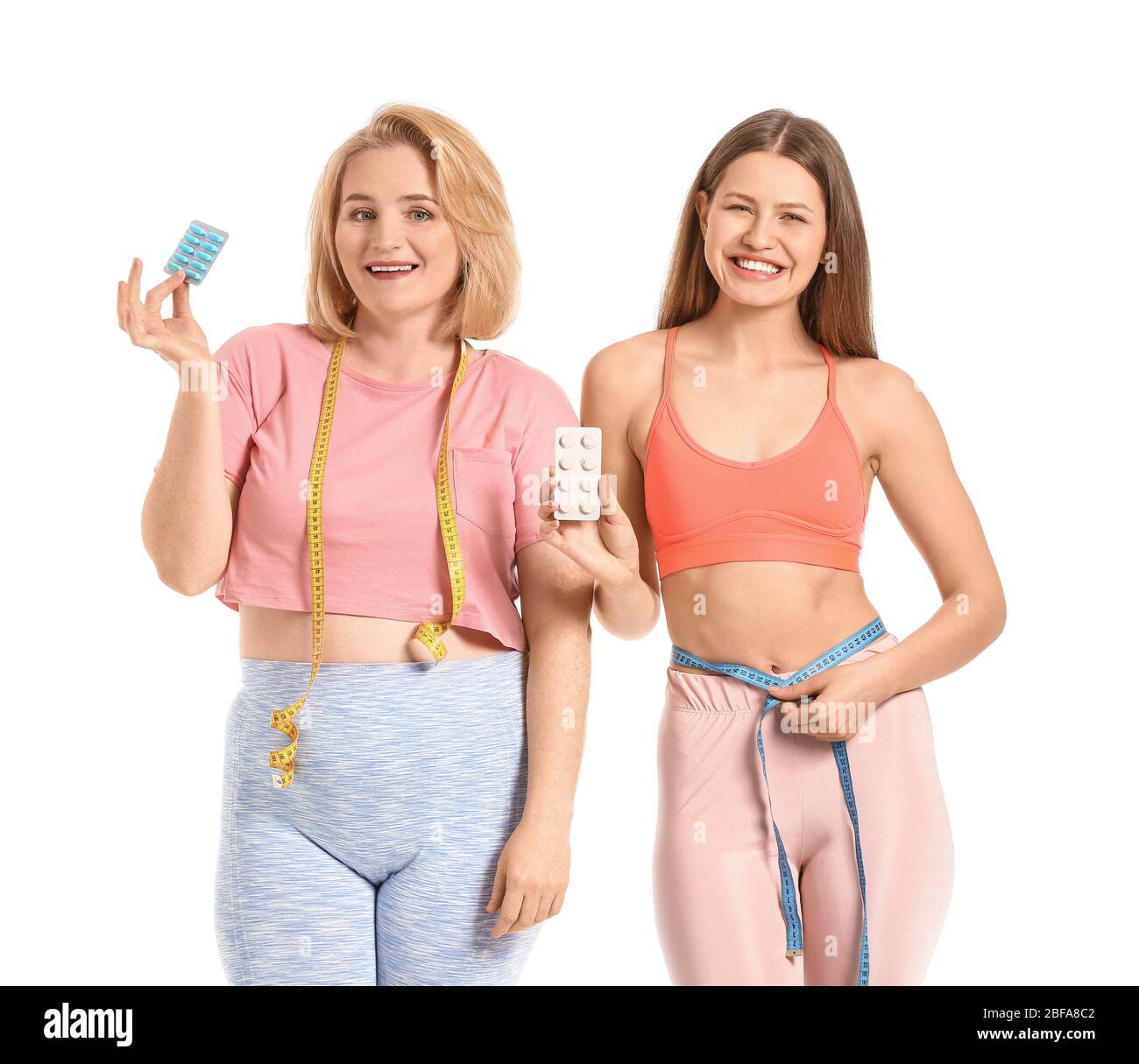 Femmes avec des pilules de perte de poids sur fond blanc Banque D'Images