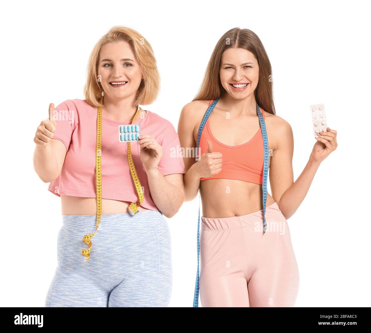 Femmes avec des pilules de perte de poids sur fond blanc Banque D'Images