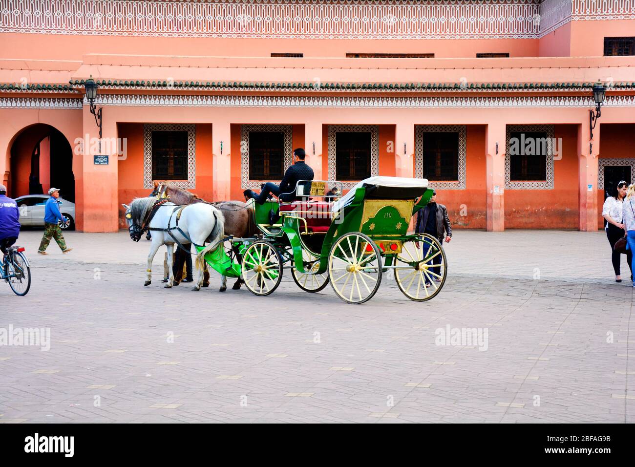 Marrakech, Maroc - 22 novembre 2014 : personnes non identifiées et entraîneur tiré par cheval, mode traditionnel de transport et attraction touristique Banque D'Images
