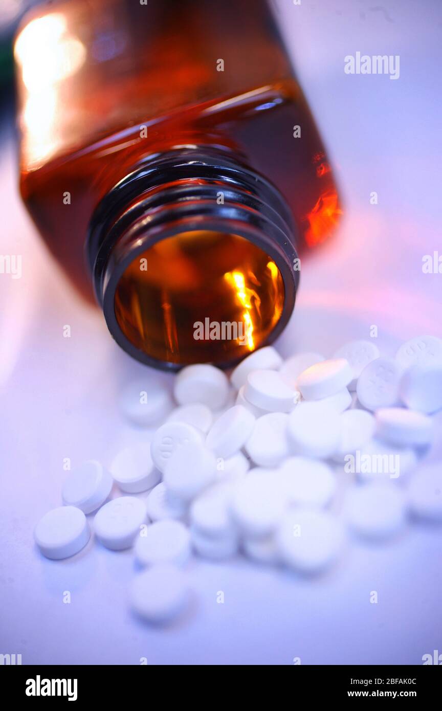 Comprimés blancs déversement provenant d'un flacon de médicaments Banque D'Images