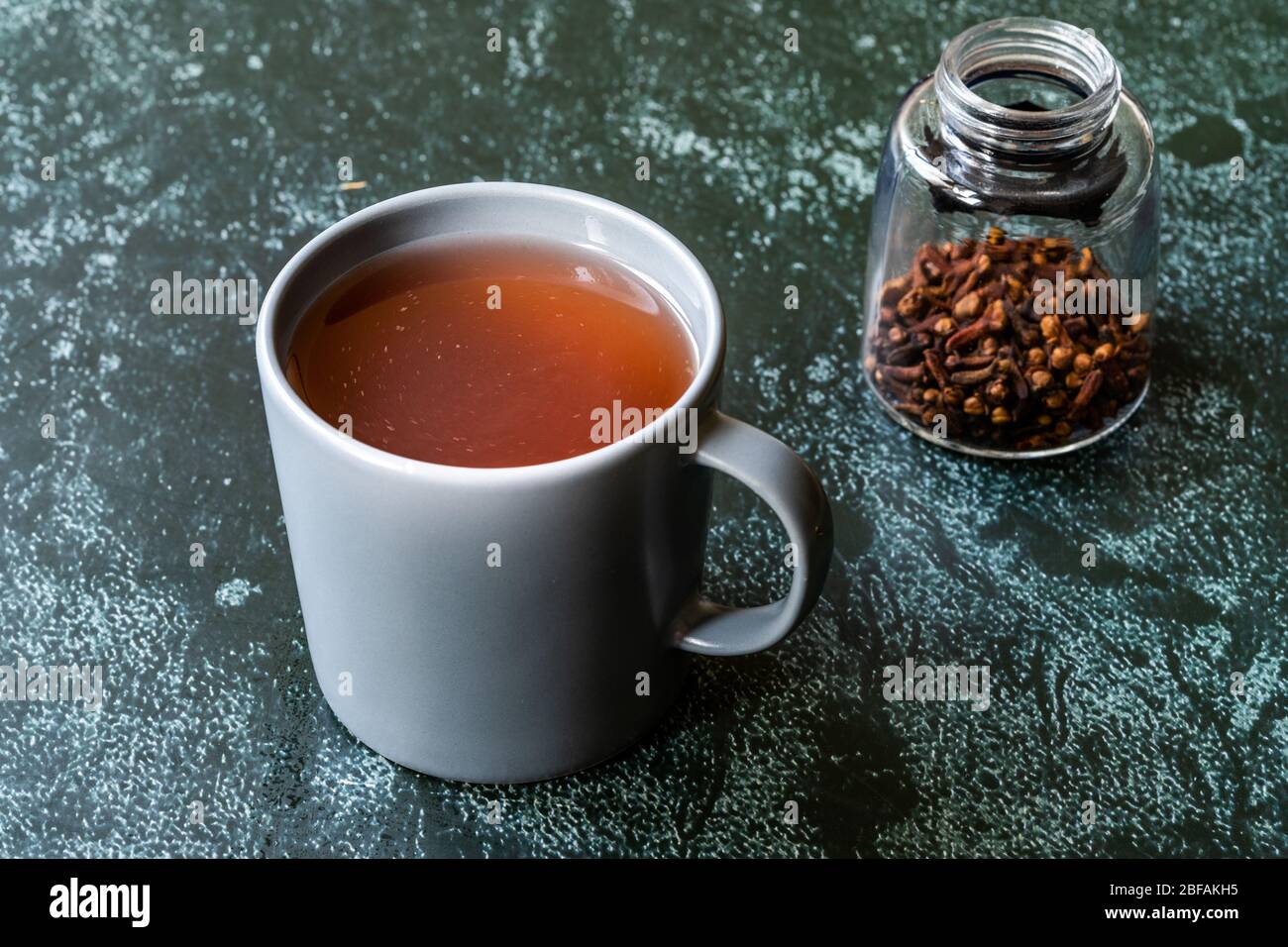 Sumac eau ou thé et épices sumac rouges secs moulues avec clous de girofle en verre. Prêt à boire. Banque D'Images