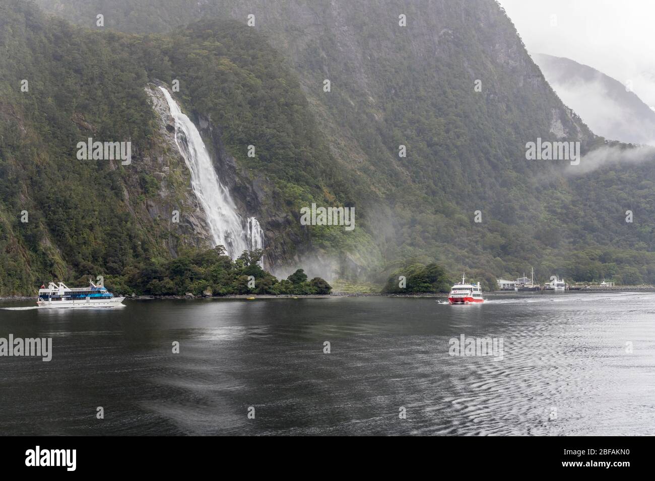 MILFORD SOUND, NOUVELLE-ZÉLANDE - 21 novembre 2019: Paysage avec navires à passagers et flottille de kayak dans le fjord de Bowen Falls, tourné en lumière vive sur non Banque D'Images