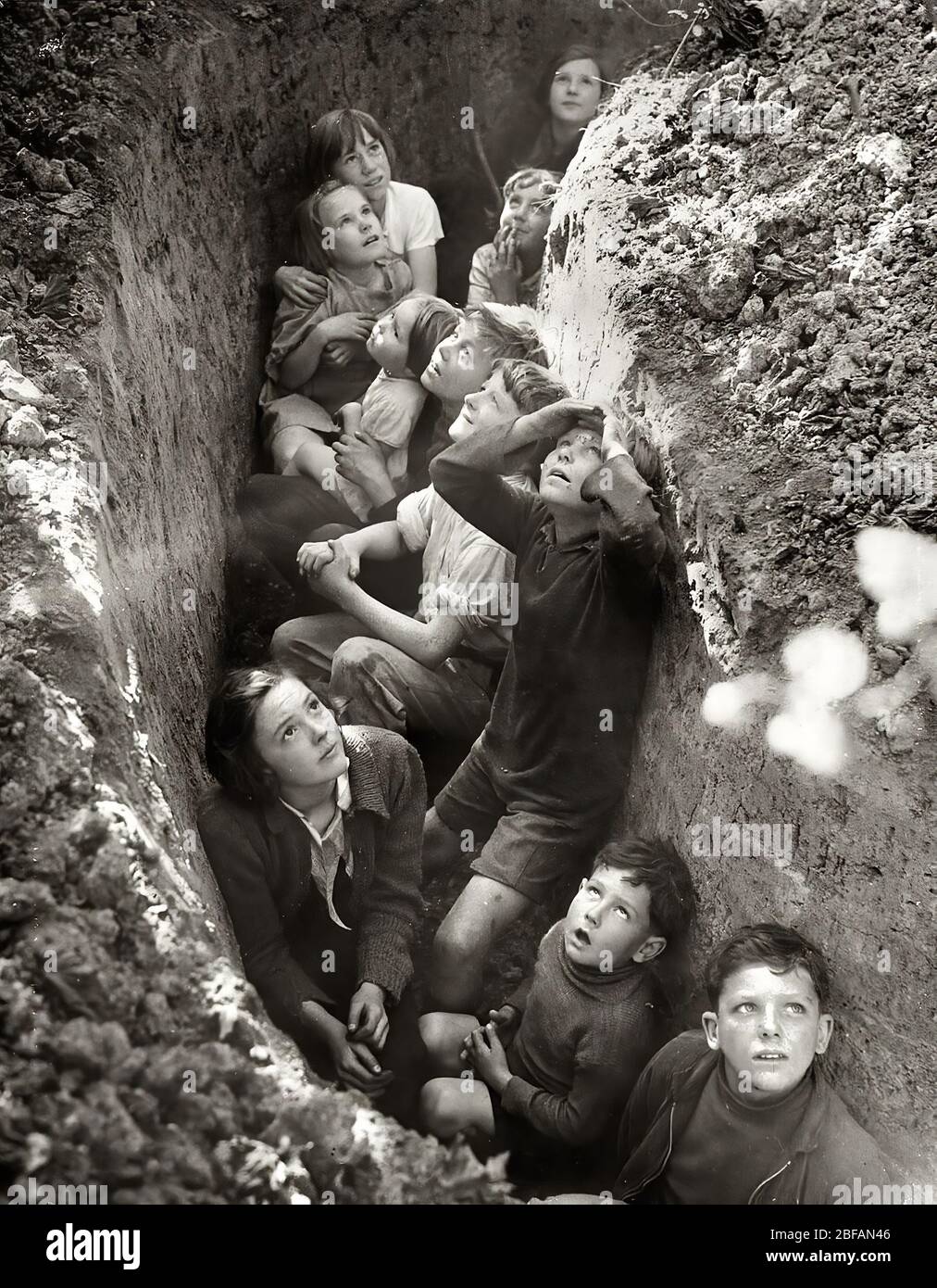 Les enfants dans l'abri des bombes tranchées pendant le Blitz, l'Angleterre, l'c. 1941 Banque D'Images