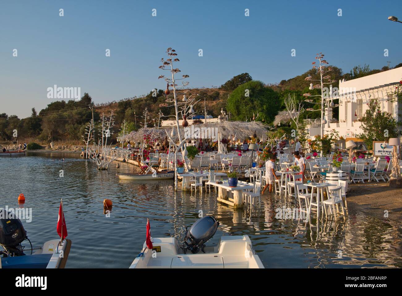 Restaurant et bougainvillea fleurs sur la plage à Gumusluk, Bodrum. Chaises, tables et fleurs colorées dans la ville de Bodrum, près de la magnifique mer Égée. Banque D'Images