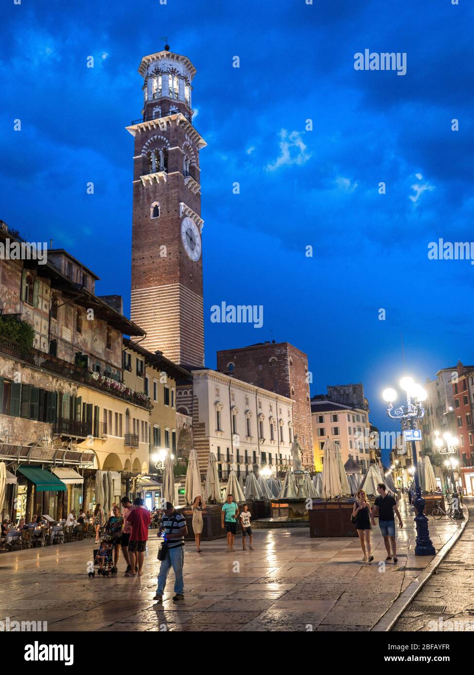 Vérone, Italie - 7 juillet 2018 : les touristes et les citoyens se promènent le soir dans une rue éclairée de Vérone romantique, Italie. Banque D'Images