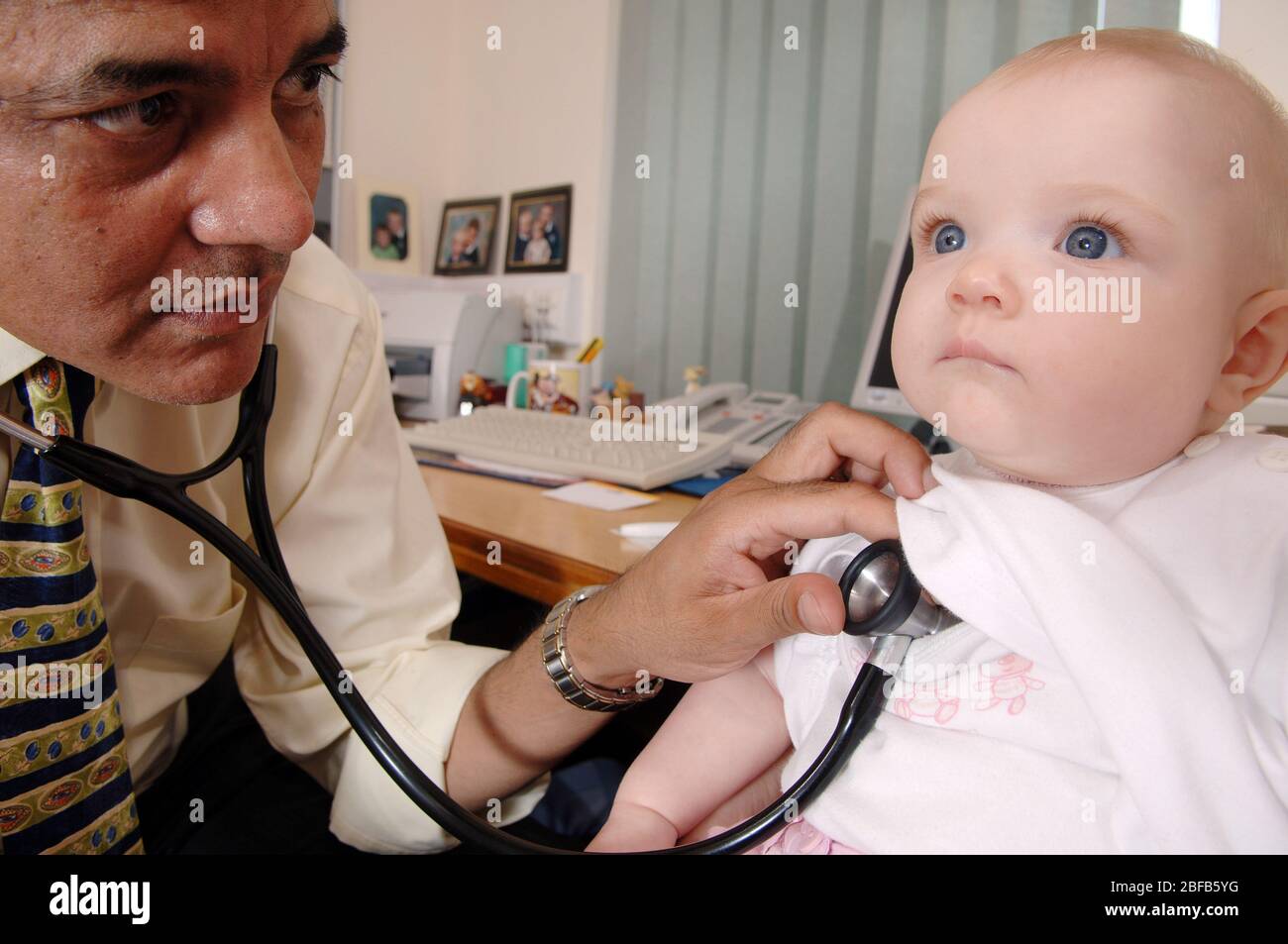 Un GP écoute les battements cardiaques d'un bébé à l'aide d'un stéthoscope (modèle libéré) Banque D'Images
