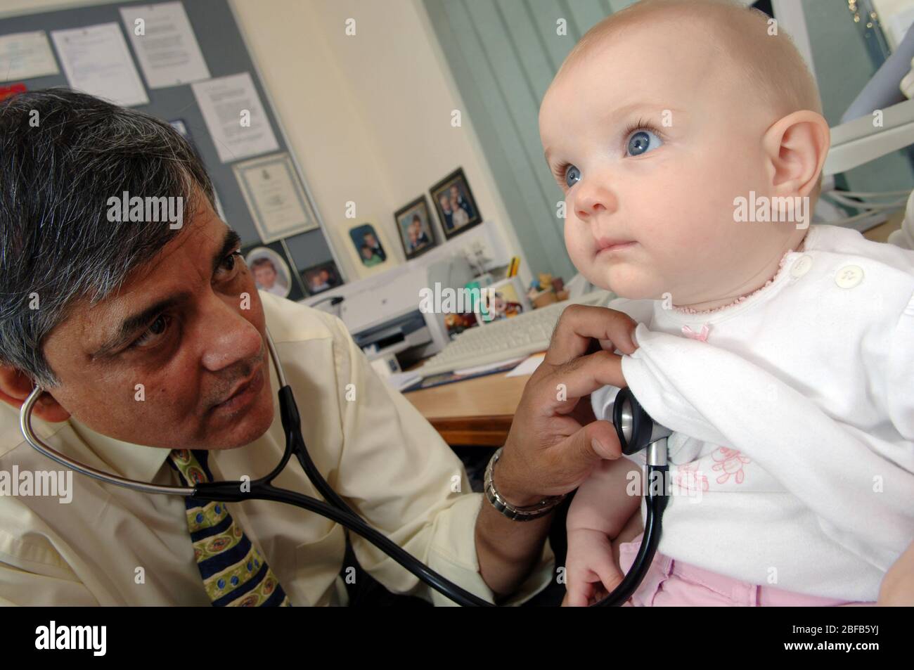 Un GP écoute les battements cardiaques d'un bébé à l'aide d'un stéthoscope (modèle libéré) Banque D'Images