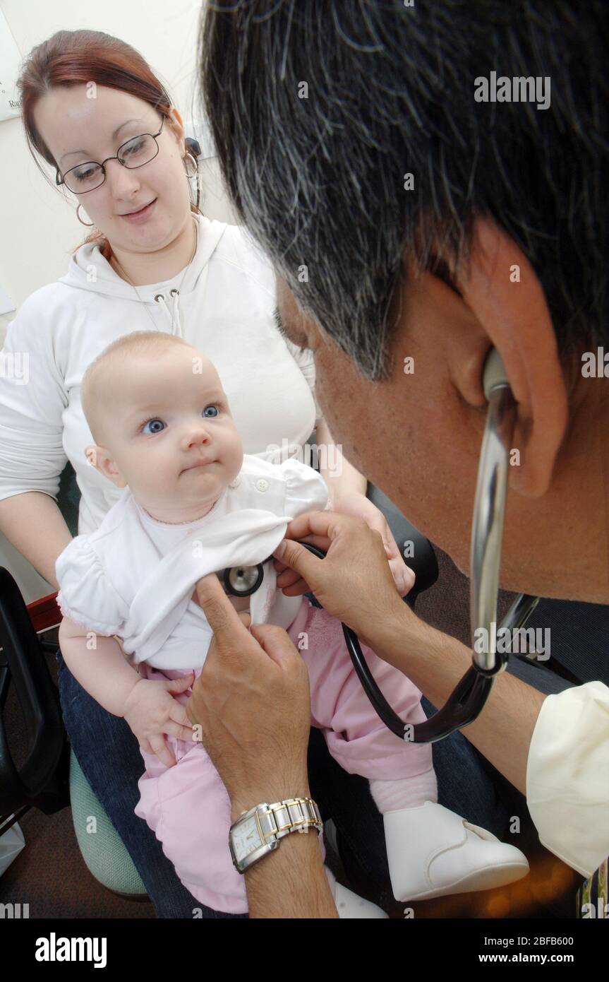 Un GP écoute les battements cardiaques d'un bébé à l'aide d'un stéthoscope (modèle libéré) Banque D'Images