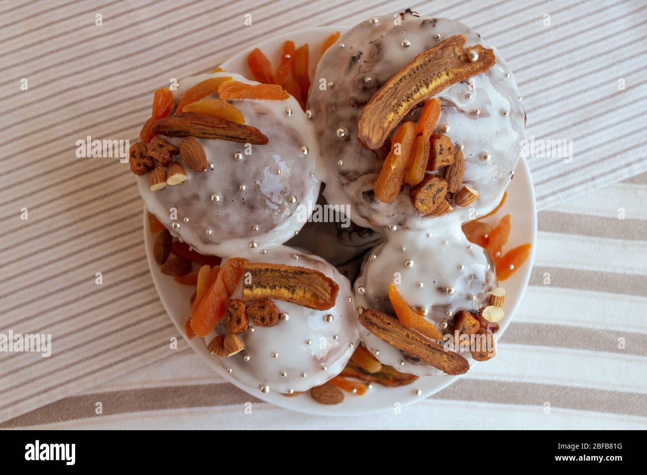 Vue sur le kulich traditionnel orthodoxe de Pâques. Quatre délicieux gâteaux élégants ensemble à la plaque décorée de bananes séchées, abricots orange, amandes Banque D'Images