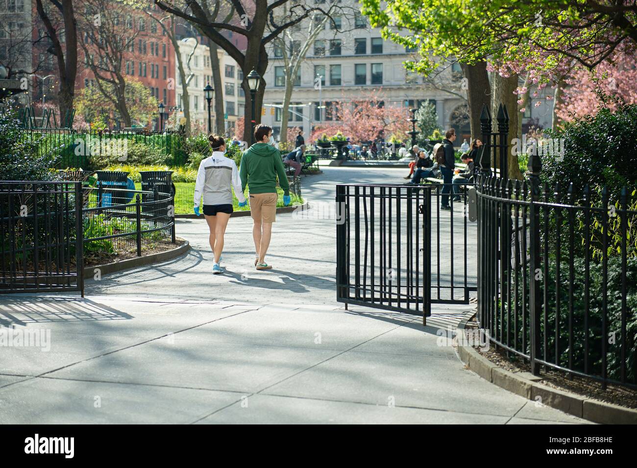 Un couple marchant à travers Madison Park pendant la pandémie de la VID19 à New York. Banque D'Images