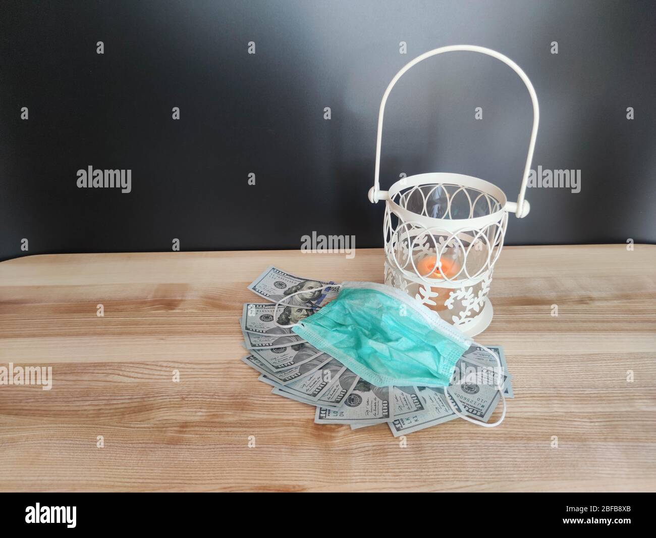 Lanterne blanche avec bougie orange, billets de 100 dollars et 