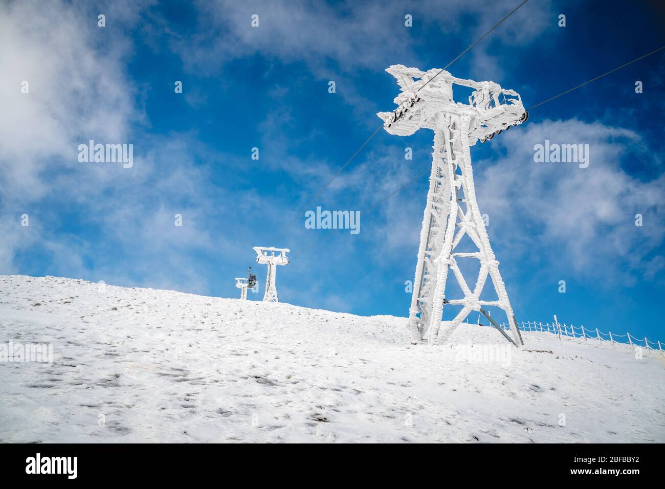 Pilier d'un remonte-pentes sur fond de ciel bleu. Krkonose, république tchèque, Snezka. Banque D'Images