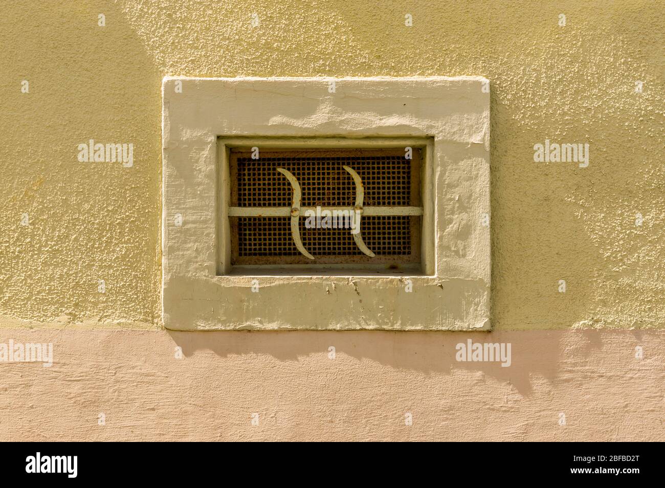 Fenêtre sous-sol grille de fenêtre en métal avec cadre en béton et fache dans belle façade en plâtre Banque D'Images