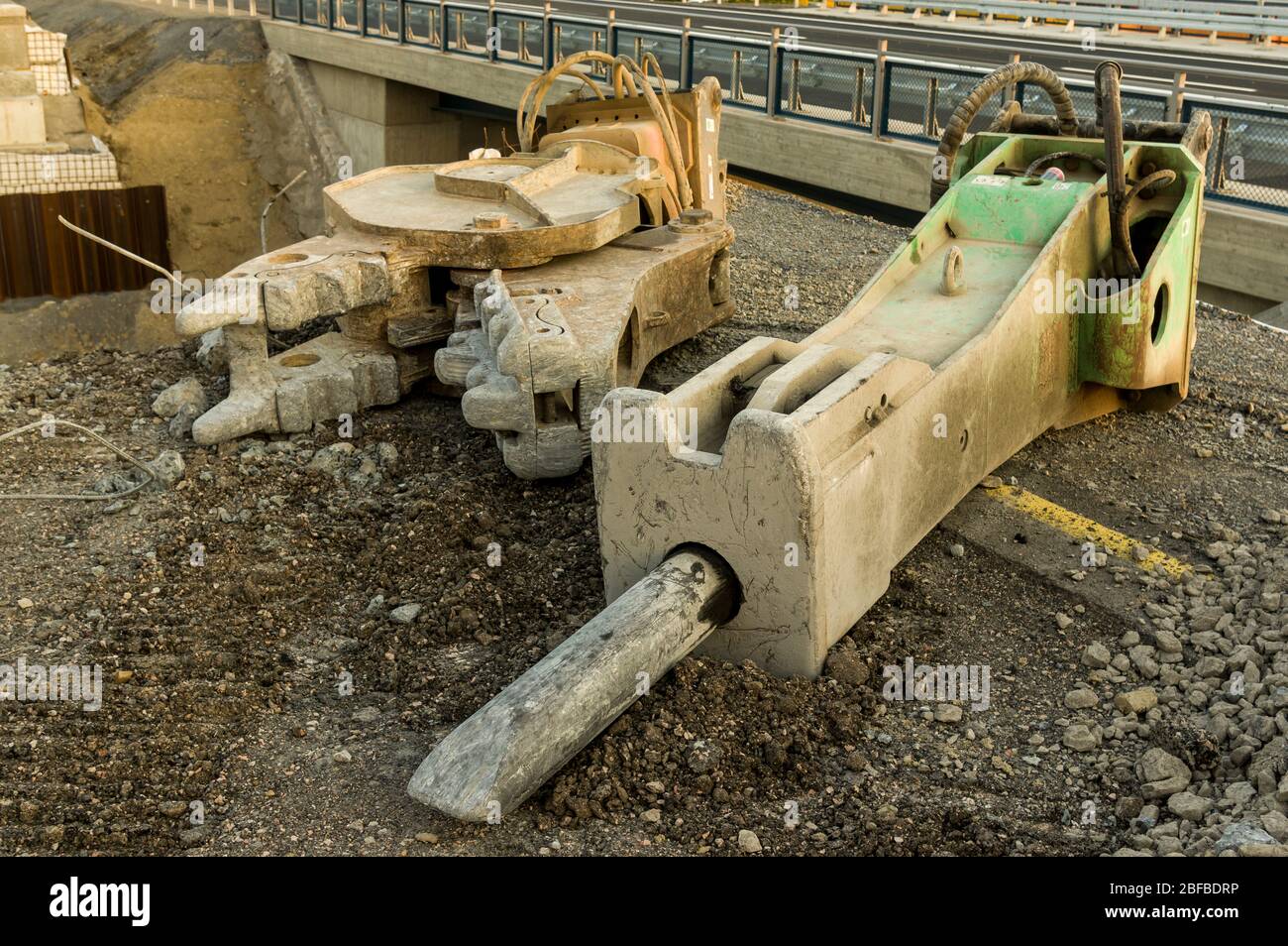 Outils d'équipement pour pelles hydrauliques, tels que marteau hydraulique avec ciseau et cisailles de démolition, gros plan sur un chantier de construction pour la construction de routes et Banque D'Images