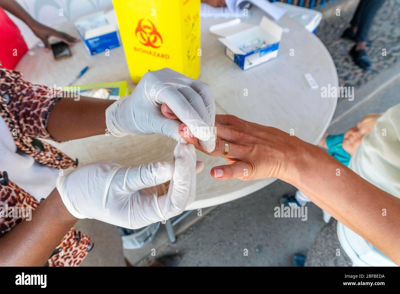 L'infirmière effectue un test rapide de paludisme à partir de sang sur la frontière sud-africaine et mozambicaine de Lebombo, en Afrique du Sud Banque D'Images