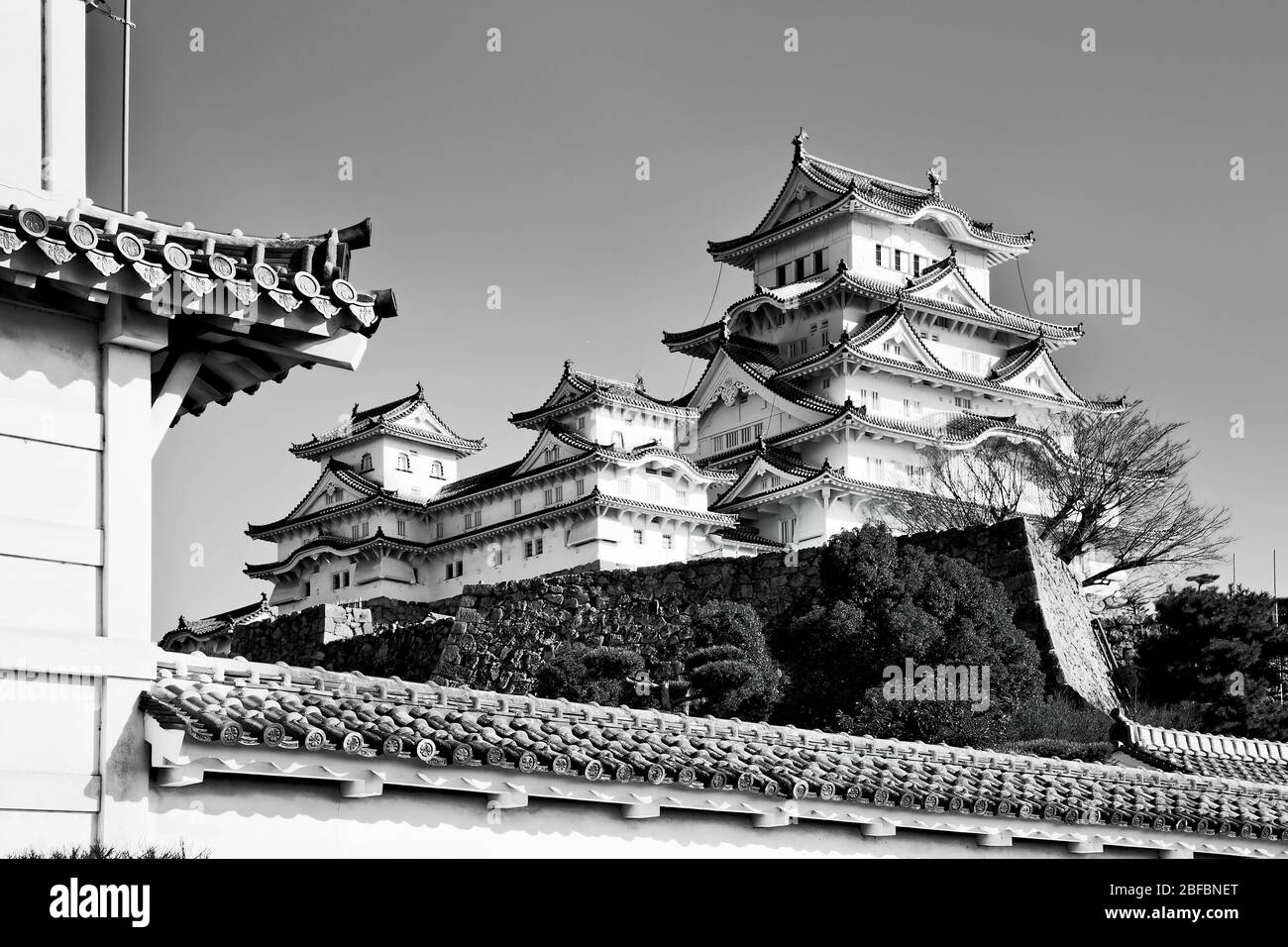 Tour et palais noir-blanc sur de grands murs en pierre dans le parc Himeji - vue panoramique contraste élevé. Banque D'Images