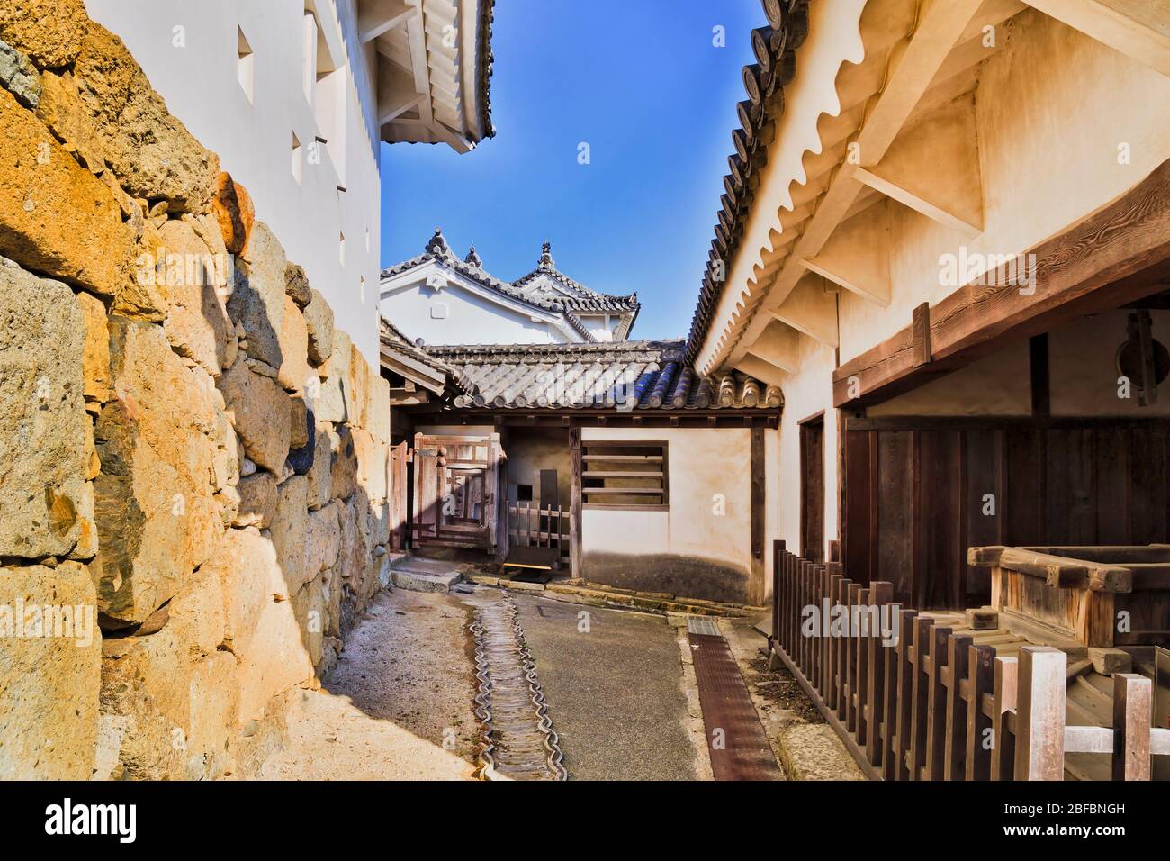 Vieux château blanc au Japon près d'Osaka - Himeji. Cour intérieure et passerelle entre les vieux bâtiments historiques et les murs en pierre. Banque D'Images