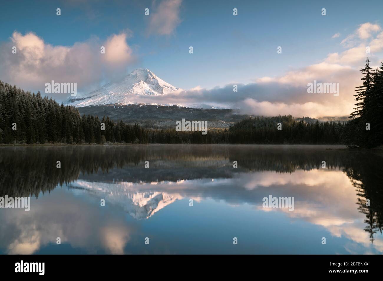 Les nuages se brisent tôt le matin, révélant une neige fraîche d'automne sur le Mt Hood de l'Oregon qui se reflète dans le lac Trillium. Banque D'Images