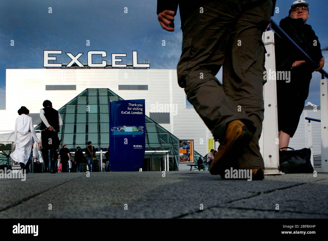 Les personnes bénéficiant de l'agréable soirée d'été à l'entrée du centre ExCel dans les Docklands de Londres. Banque D'Images