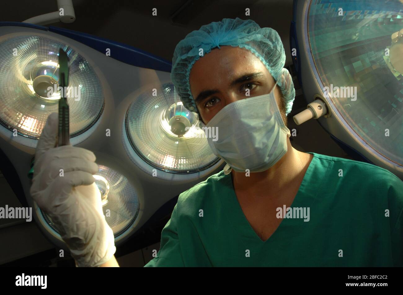 Gros plan sur un chirurgien de l'hôpital qui tient un scalpel sous les lampes du théâtre d'opération Banque D'Images