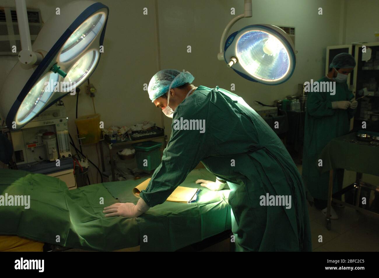 Le chirurgien de l'hôpital regarde les notes de son patient avant la chirurgie Banque D'Images