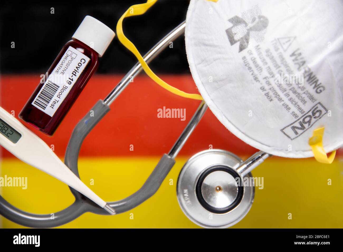 Concept de coronavirus ou de pandémique Covid-19 avec drapeau allemand de pays et test sanguin, stéthoscope, masque chirurgical N 95, thermomètre Banque D'Images Concept de coronavirus ou de pandémique Covid-19 avec drapeau allemand de pays et test sanguin, stéthoscope, masque chirurgical N 95, thermomètre Banque D'Images
