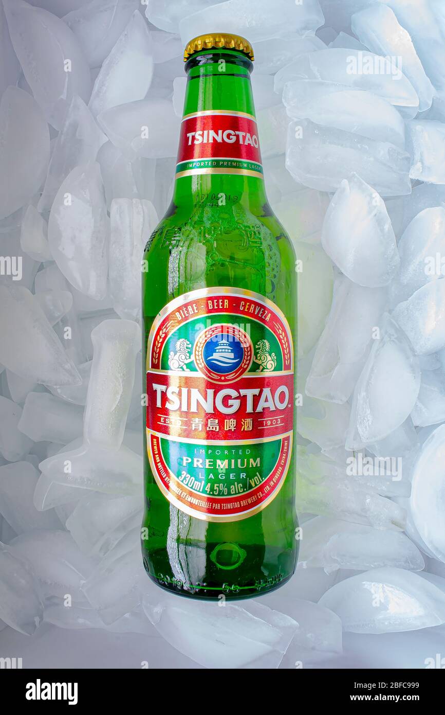 Calgary, Alberta, Canada. 17 avril 2020. Une bouteille de bière Tsingtao sur un lit de glace. Banque D'Images