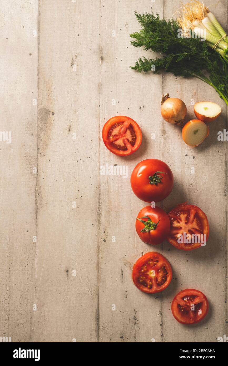 Tomates fraîches, aneth et oignons sur une surface en bois de couleur claire Banque D'Images