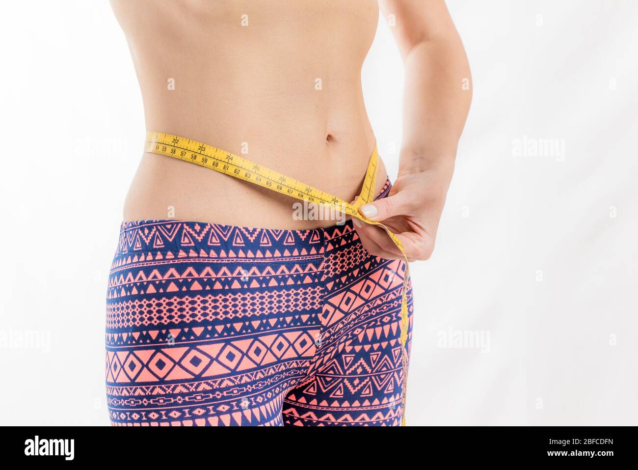 Femme de fitness mesurant sa taille, perte de poids Banque D'Images