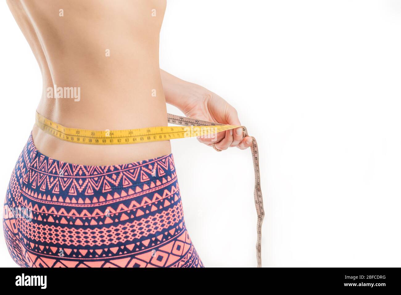 Femme de fitness mesurant sa taille, perte de poids Banque D'Images