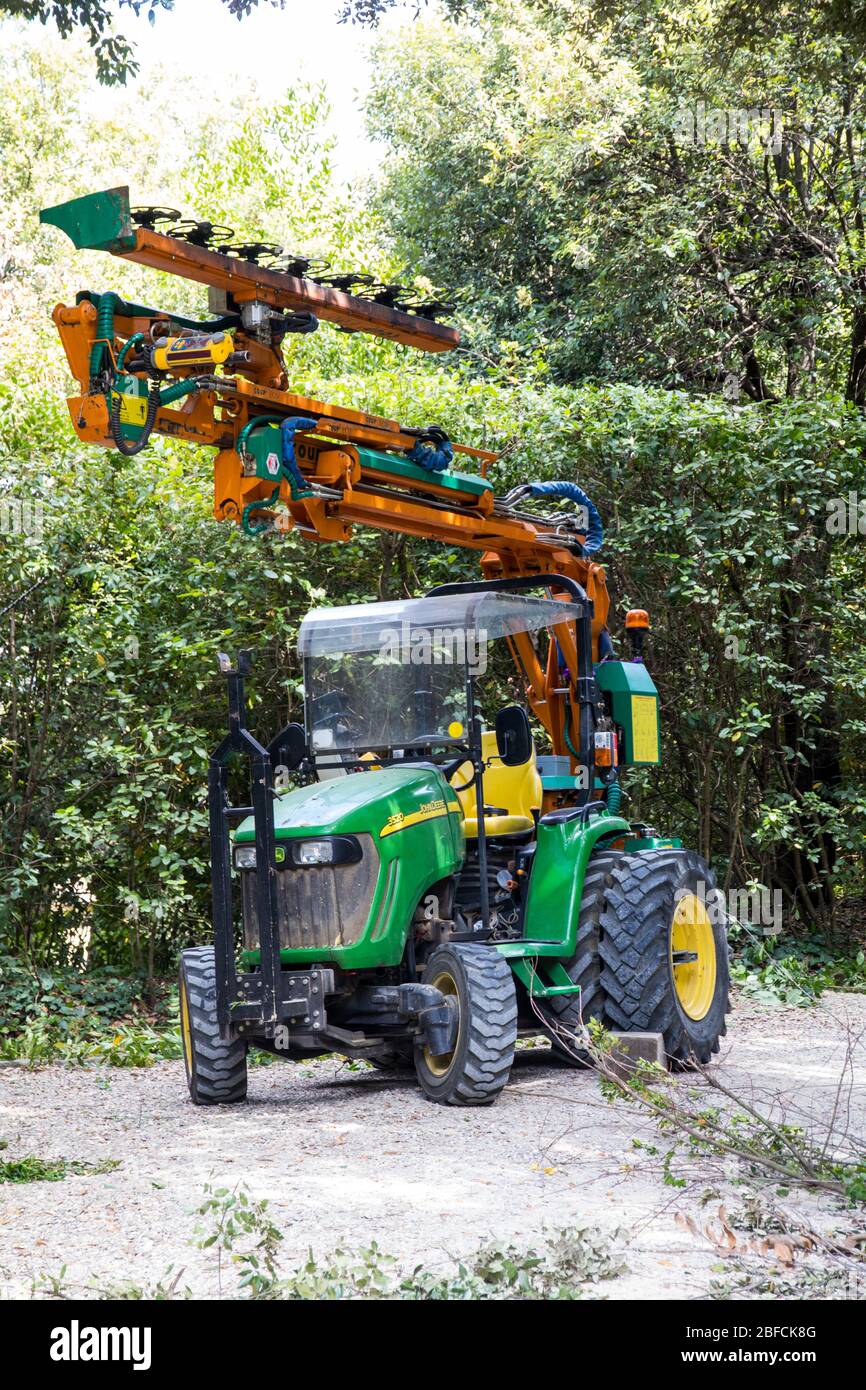 Tracteur avec dispositif pour l'élagage et la coupe d'arbres Banque D'Images