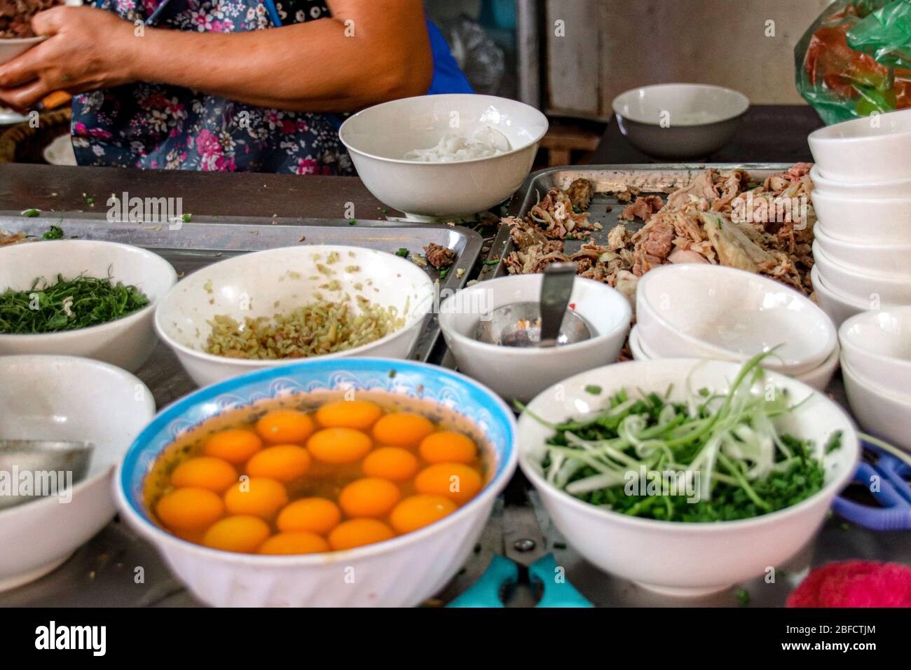 Street food stall vendant des nouilles vietnamiennes traditionnelles ou pho dans les rues de la ville de Hanoi qui montre la culture et la tradition alimentaire du Vietnam Banque D'Images