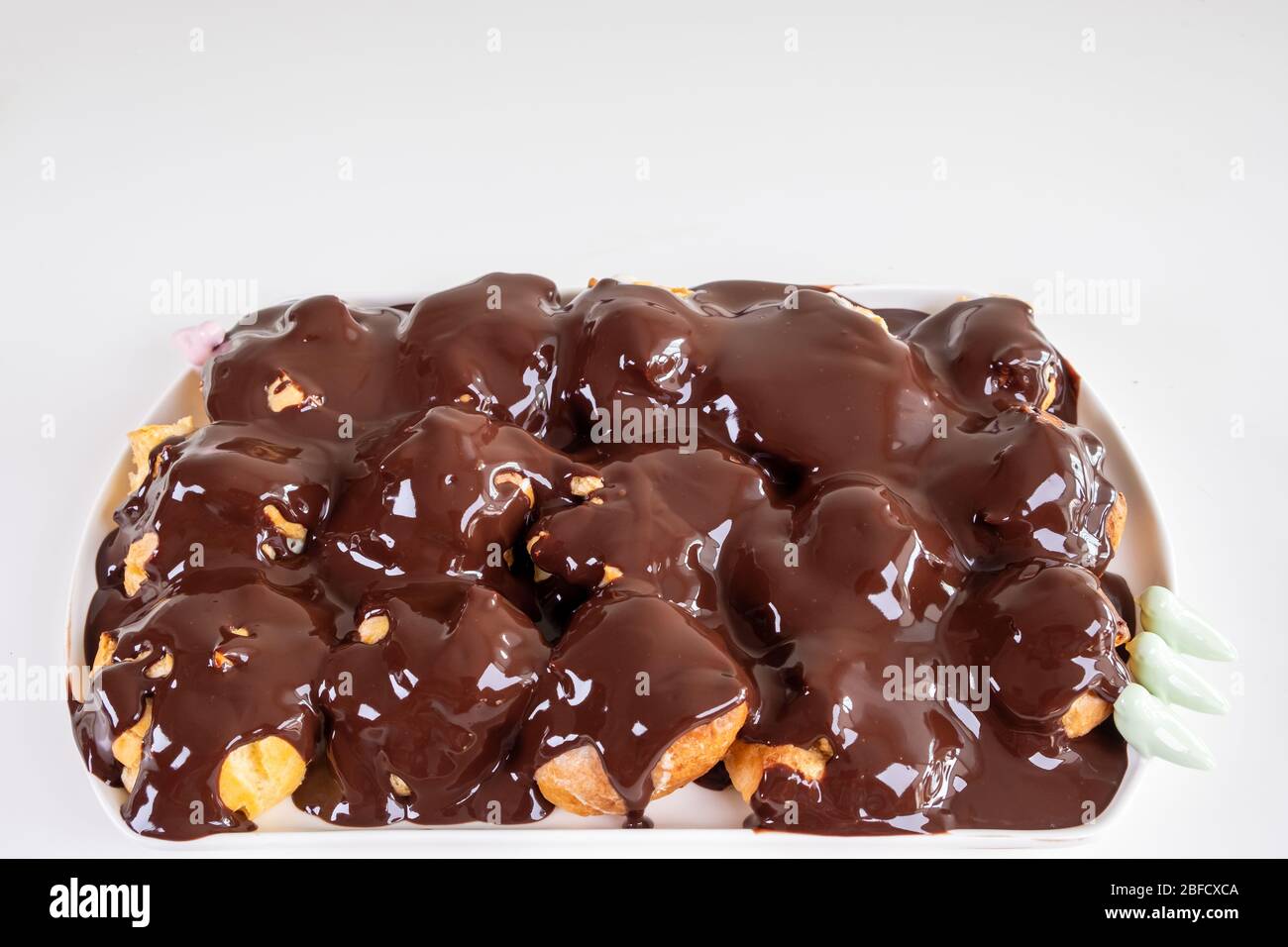 Pourvoirie au chocolat. Dessert sucré sur une assiette blanche. Profiteroles maison avec sauce crème et chocolat. Banque D'Images