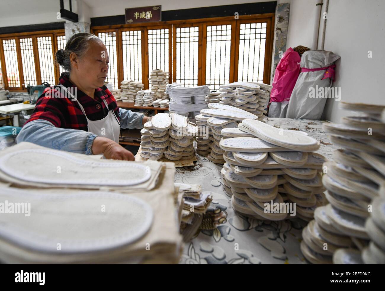 (200418) -- CHENGDU, 18 avril 2020 (Xinhua) -- Lai Shufang organise des semelles de chaussures faites main dans le village de Zhanqi, dans le canton de Tangchang, dans la province du Sichuan, dans le sud-ouest de la Chine, 17 avril 2020. Lai Shufang, 62 ans, est engagé dans la fabrication de chaussures Tangchang artisanales depuis plus de 40 ans. Dans le canton de Tangchang, la famille de Lai est la seule à avoir encore des chaussures en tissu Tangchang, qui présentent 32 procédures avant sa fin. Comme de nombreux artisans, Lai était autrefois inquiet que l'artisanat disparaisse et qu'il n'y aurait pas d'héritiers. Cependant, l'artisanat a ouvert sa voie Banque D'Images