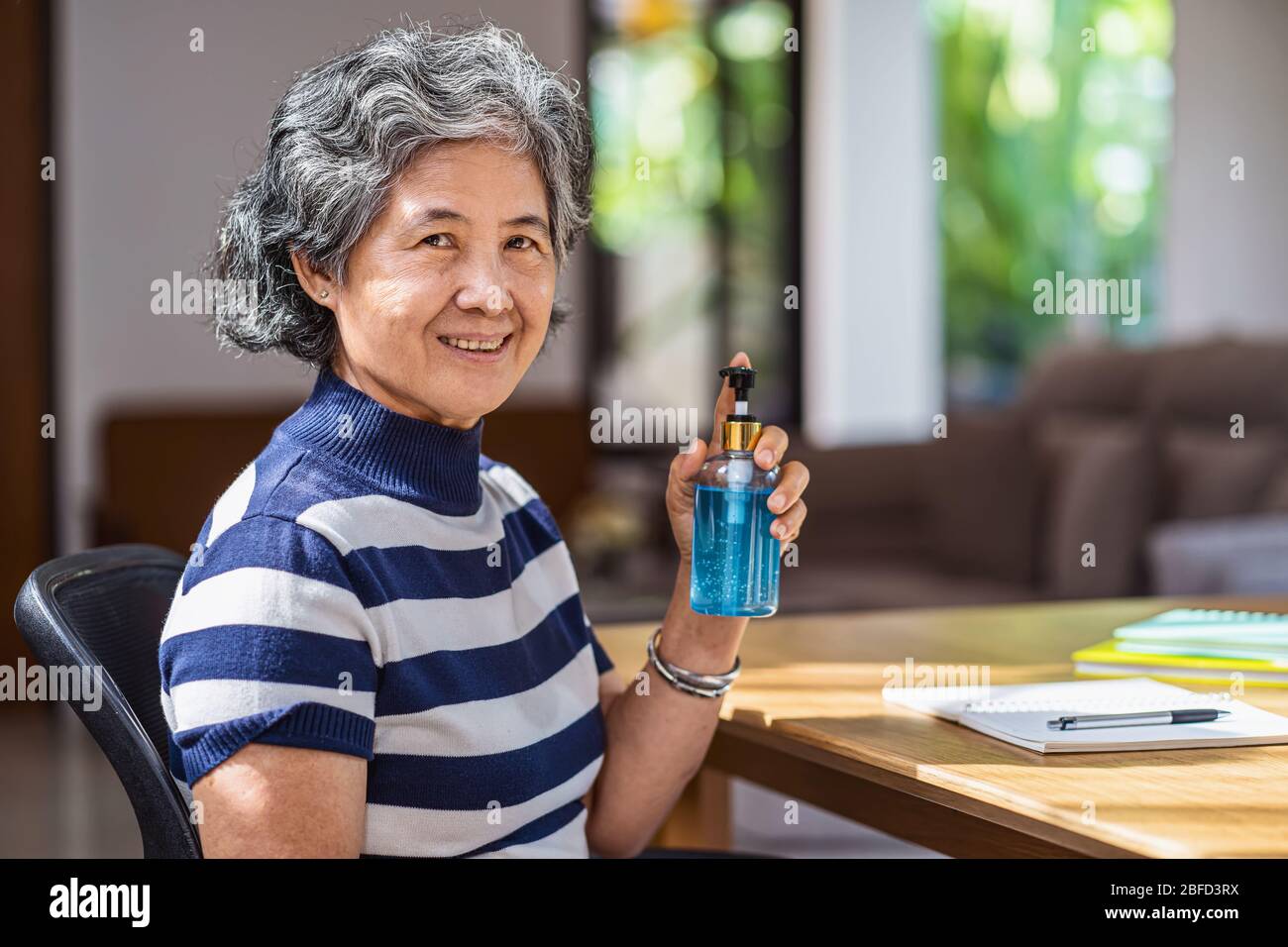 Portrait de la vieille femme asiatique montrant l'aseptisant à la main en pompant le gel d'alcool et en se lavant avant de travailler à partir de la période de la maison, du coronavirus ou du covid Banque D'Images