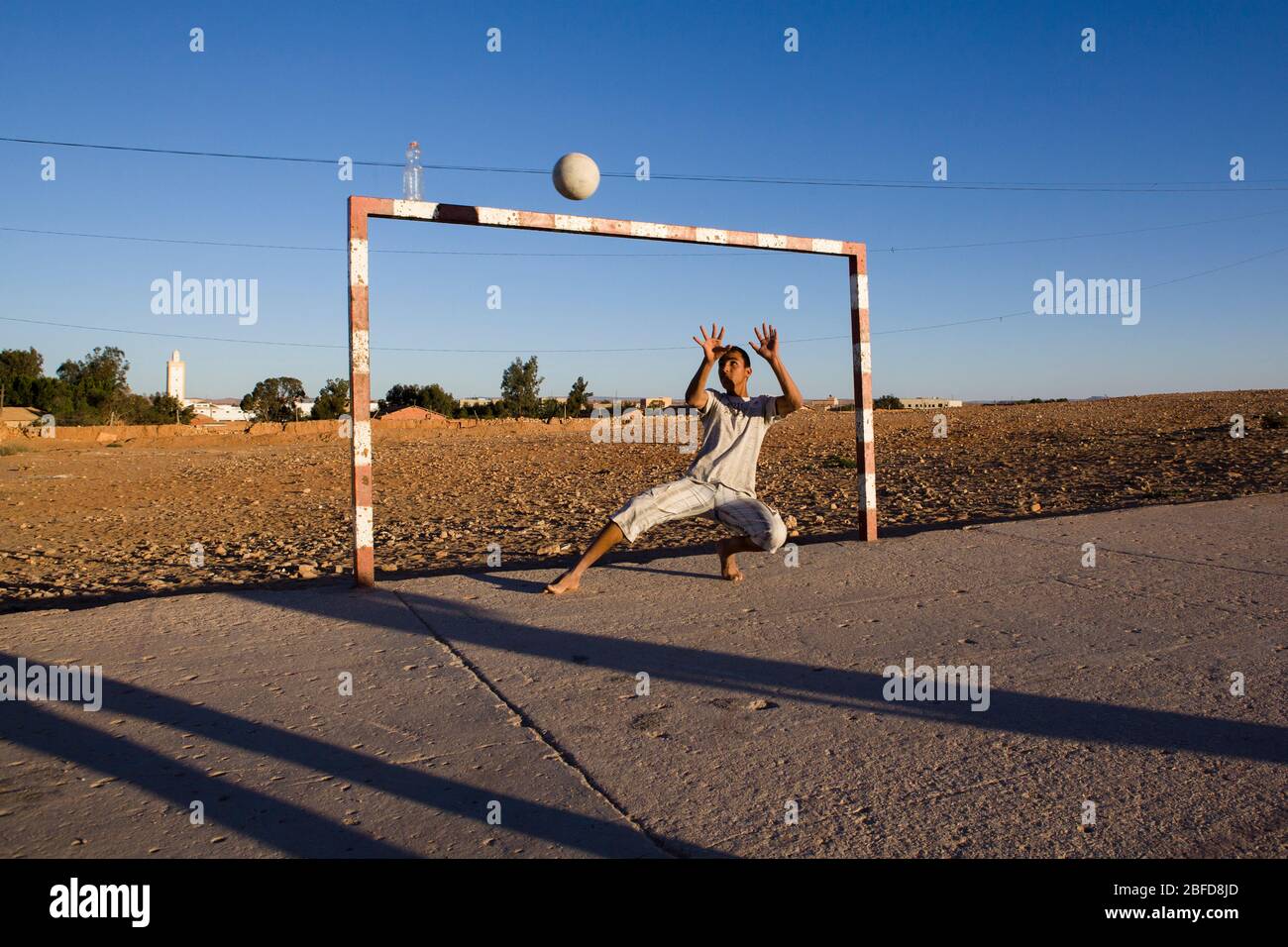 Garçon marocain jouant gardien de but au Sahara occidental, Maroc. Banque D'Images