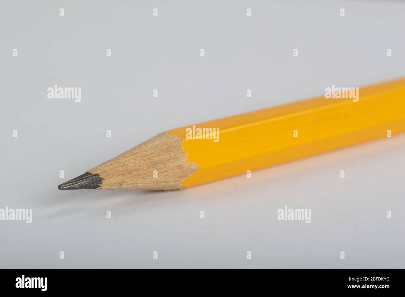 Une photo d'un crayon jaune, prise sur son côté sur un fond blanc Banque D'Images