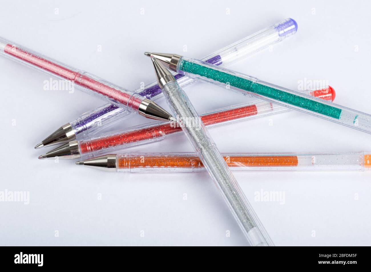 Une sélection de stylos à gel pailleté colorés sur un fond blanc Banque D'Images