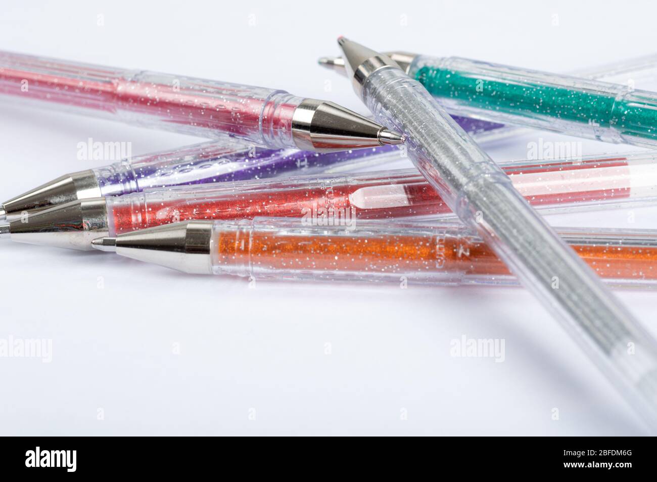 Une sélection de stylos à gel pailleté colorés sur un fond blanc Banque D'Images