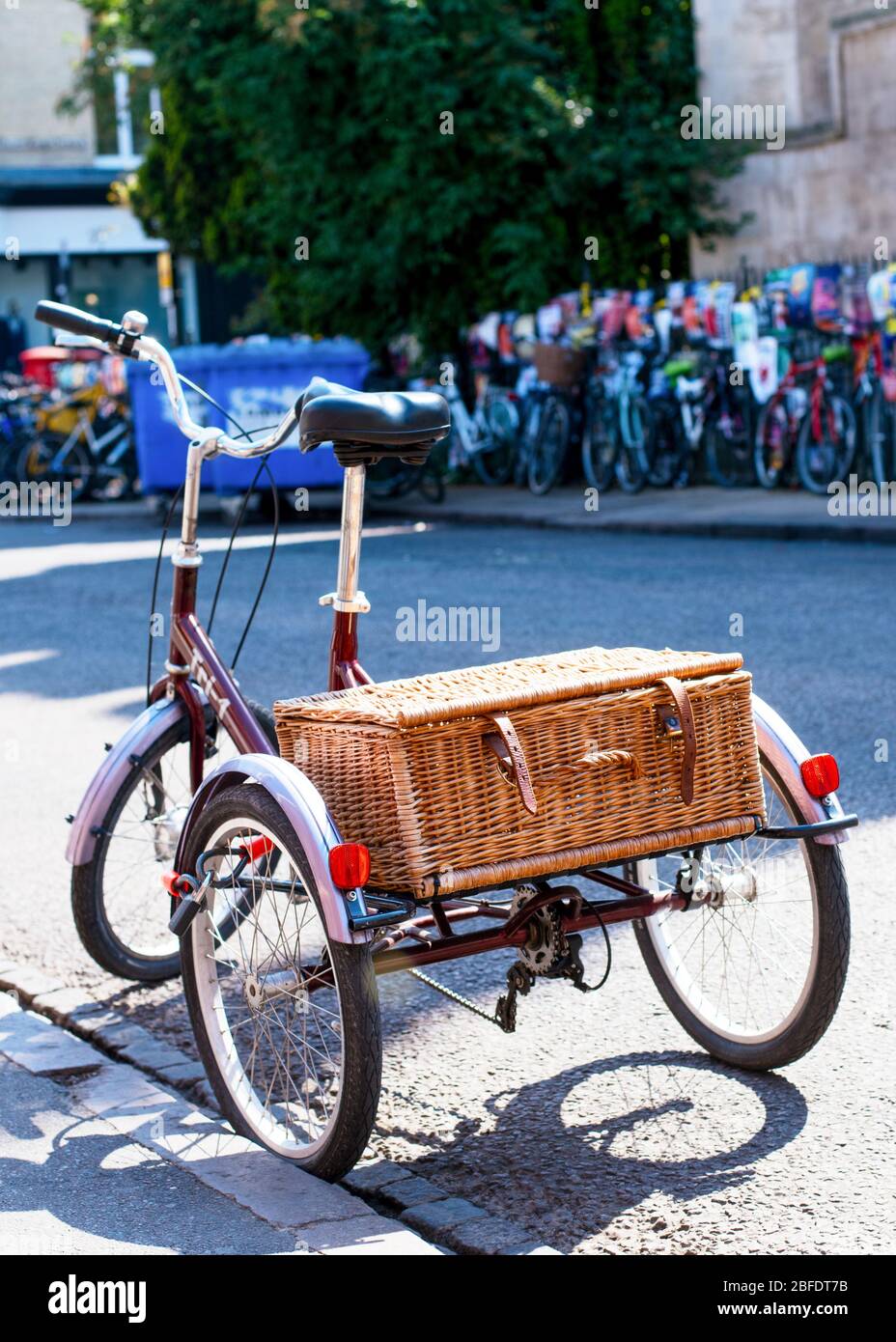 Un vieux tricycle / vélo avec un panier de paille dans une rue à Cambridge Banque D'Images