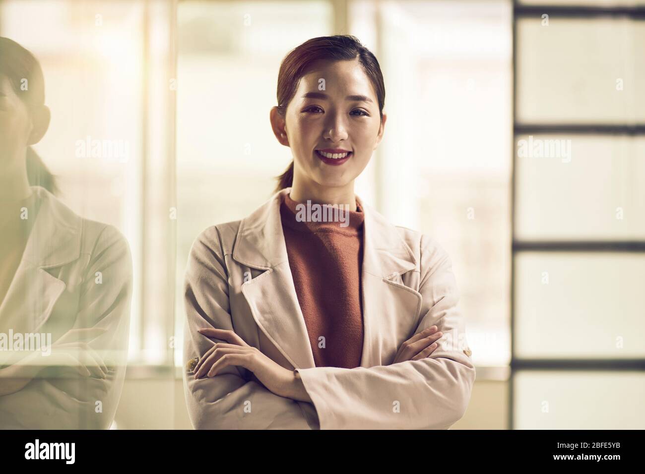 portrait d'un jeune entrepreneur asiatique d'affaires réussi regardant l'appareil photo souriant Banque D'Images